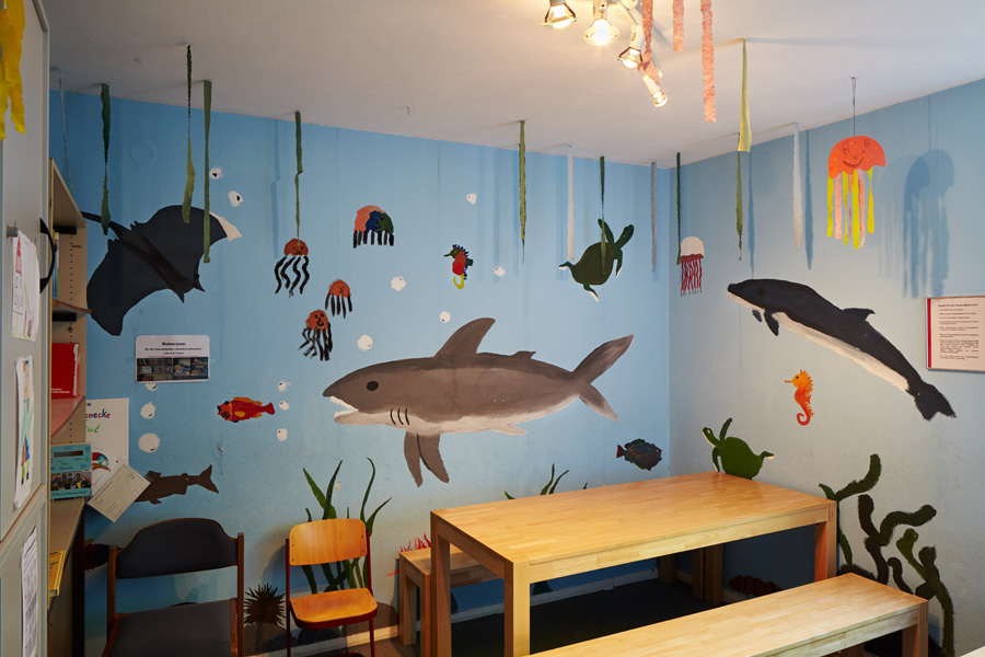 aufenthaltsraum für die schüler:innen // die wände sind mit einem haifisch und delphin und anderen meerestieren bemalt. daher der spitzname - das aquarium.