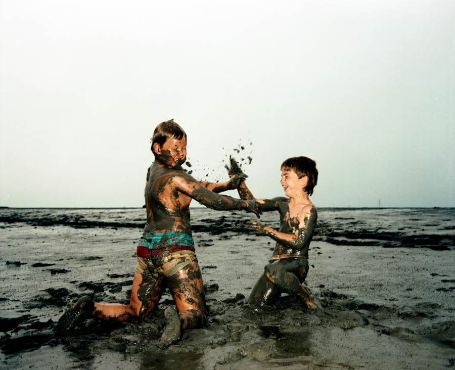 im watt: zwei jungen beschmeissen sich mit schlamm / in the mudflats: two boys throw mud on each other // 
Auftrag / Commission: STERN, Sommer in Deutschland / summer in germany (west) 1989